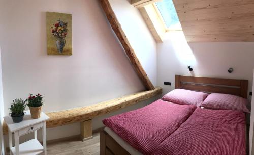 a bedroom with a pink bed in a attic at Roubenka Kuklík in Sněžné