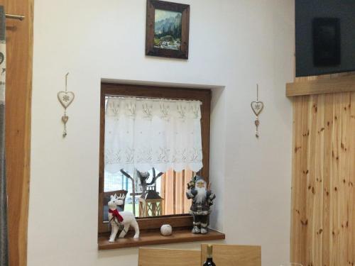 a window with a dog sitting on a shelf at Villa Garden in Bešeňová