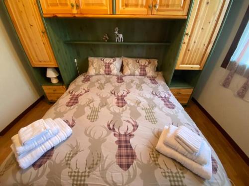 a bedroom with a bed with two towels on it at [App. Tremol] 50 mt da piste sci in Piancavallo