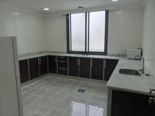 uma cozinha vazia com um lavatório e uma janela em Al Salam Resort em Al Khiran