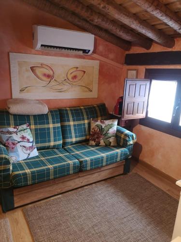 a living room with a couch and a window at Ático Pirón in Adrada de Pirón