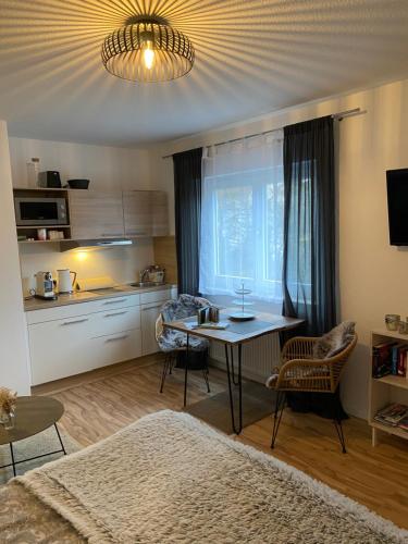 ein Wohnzimmer mit einem Tisch und einer Küche in der Unterkunft Kuschelnest Michelstadt in Michelstadt