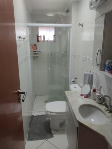 a bathroom with a toilet and a shower and a sink at Ap 1 dormitório Praia Grande(canto do forte) 100m da praia in Praia Grande