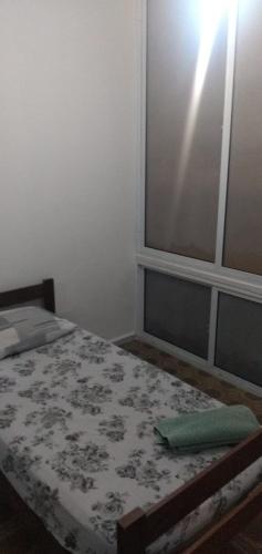 a small bedroom with a bed with a window at Conceitual Hostel Natal in Natal