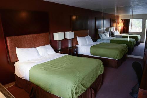 een hotelkamer met 2 bedden en groene lakens bij Relax Inn in Collinsville