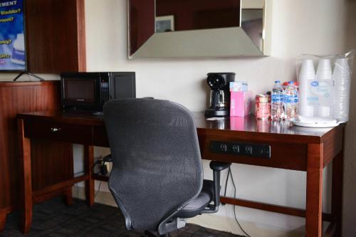a desk with a chair in a hotel room at Relax Inn in Collinsville