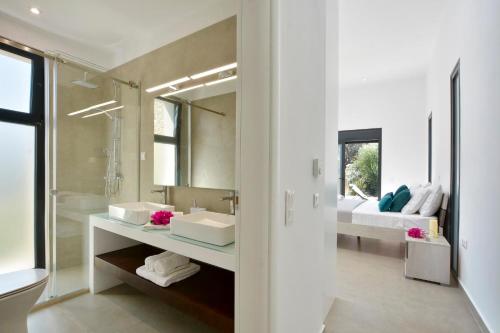 baño con 2 lavabos y espejo grande en Villa Kalloni en Línia