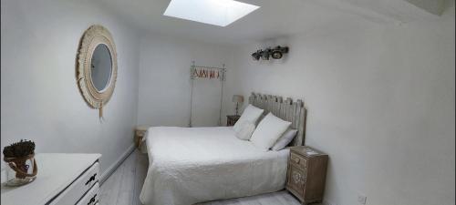 Habitación blanca con cama y espejo en Latipik, en Lançon-Provence