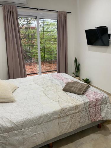 Schlafzimmer mit einem großen Bett und einem Fenster in der Unterkunft Wawa Estudio 3 in Posadas