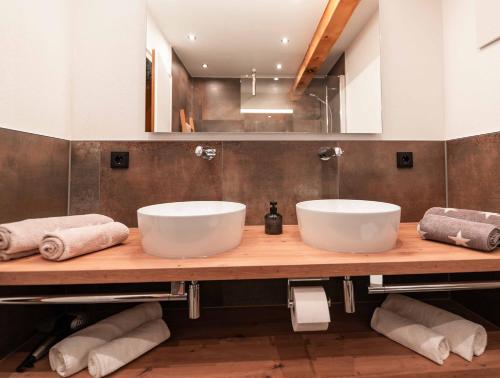 two sinks on a wooden counter in a bathroom at Ferienhaus Riss in Bolsterlang