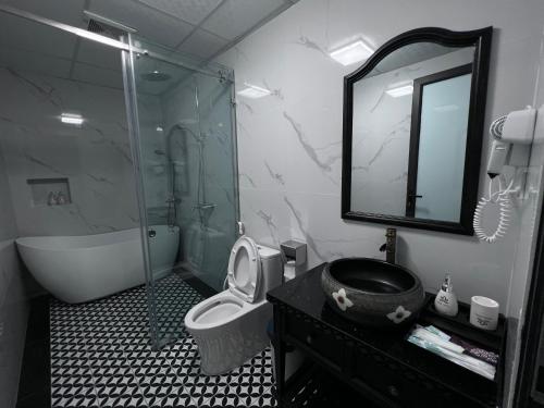 a bathroom with a shower and a toilet and a mirror at Lotus Hotel Ninh Bình in Ninh Binh