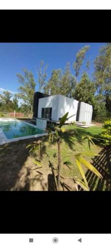 een huis met een palmboom voor een zwembad bij Quinta La Pitu in San José del Rincón