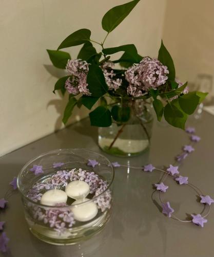 a glass vase with flowers and candles on a table at Hotel Risi in Colico