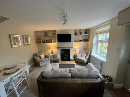 a living room with a couch and a fireplace at Cosy two bed townhouse in Centre of C.Norton in Chipping Norton