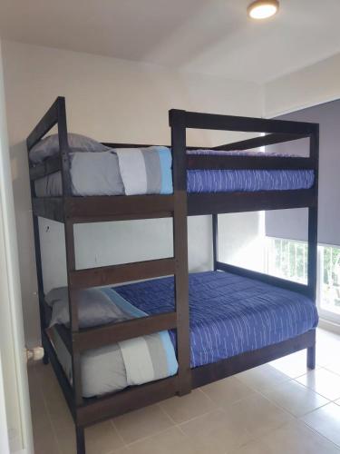 a room with a bunk bed with blue and white pillows at Ideal para estar en Familia in Cancún
