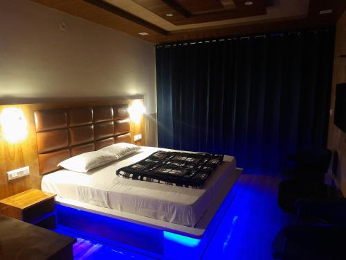 a bedroom with a bed with blue lights on it at Aagaman Woods in Shimla