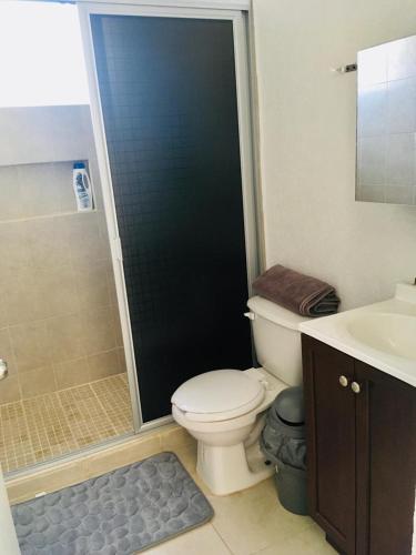 a bathroom with a toilet and a shower and a sink at Ideal para estar en Familia in Cancún