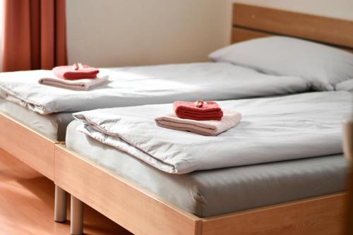 três camas com toalhas cor-de-rosa em cima em Heidi em Saas-Fee