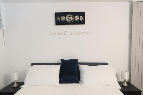 - une chambre avec un lit blanc et des oreillers blancs dans l'établissement Central Watford Apartment, à Watford