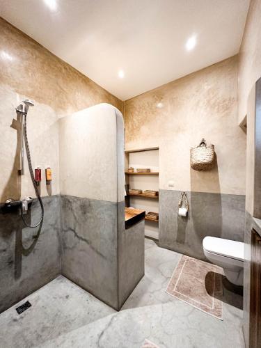 uma casa de banho com um chuveiro e um lavatório. em Riad Darsahalia em Marrakech