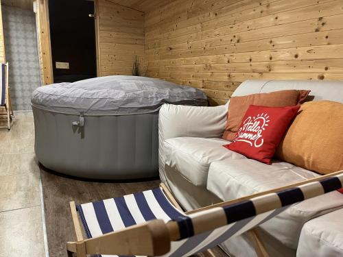 a living room with a couch and a large tub at Idill Cottage Vendégház in Tiszafüred