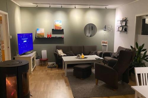 ein Wohnzimmer mit einem Sofa und einem TV in der Unterkunft Skogstad Ferie og fritid in Tromsø