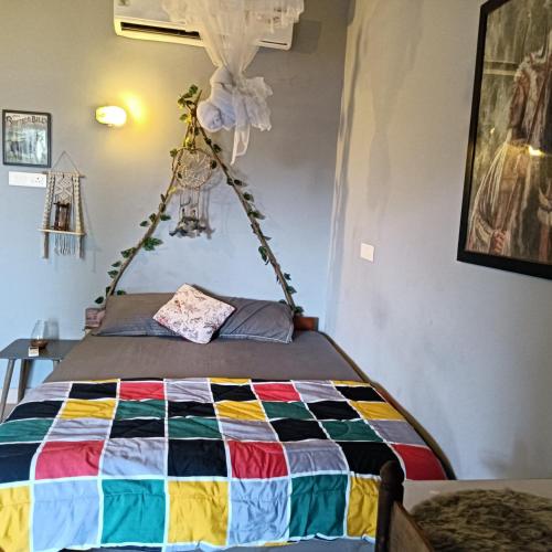 a bed in a room with a colorful quilt at De CaveMan Goa A Jungle Retreat in Arambol