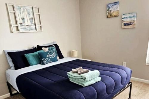 a bedroom with a large blue bed with towels on it at Cheerful 4 Bedroom Salt Water Heated Pool & Spa in Riverview
