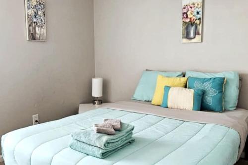 a bedroom with a large bed with towels on it at Cheerful 4 Bedroom Salt Water Heated Pool & Spa in Riverview
