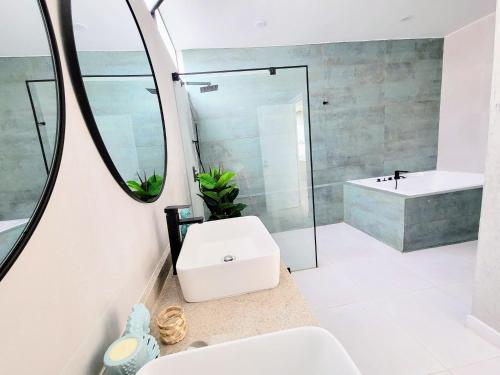 uma casa de banho com um lavatório e um espelho em HERMOSA CASA CON PISCINA FRENTE AL MAR - PRIMERA FILA em Chincha Baja