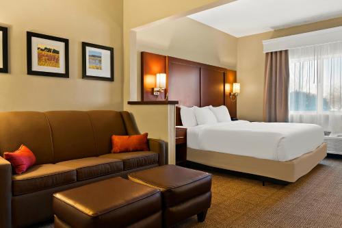 ein Hotelzimmer mit einem Bett und einem Sofa in der Unterkunft Comfort Suites in Saginaw