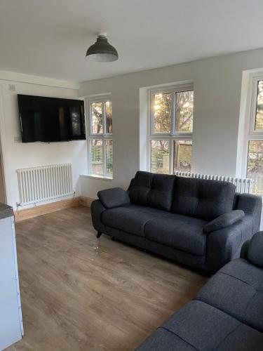 a living room with a couch and a flat screen tv at Upsall Warren Cottage in Middlesbrough