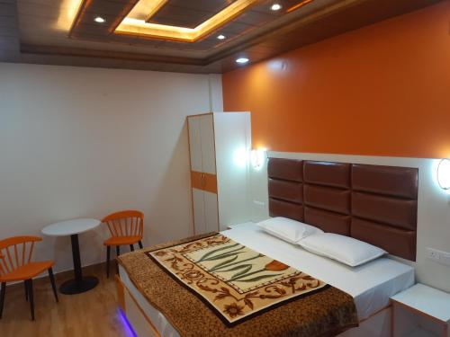 a bedroom with a bed and two chairs and a table at Aagaman Woods in Shimla