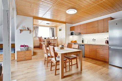 eine Küche mit Tisch und Stühlen und einem Kühlschrank in der Unterkunft APARTMÁN U MAXÍKŮ in Černý Důl