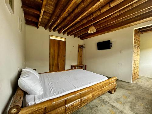een slaapkamer met een houten bed in een kamer bij Finca el Manantial Isnos, habitación Alas de Chocolate in Isnos