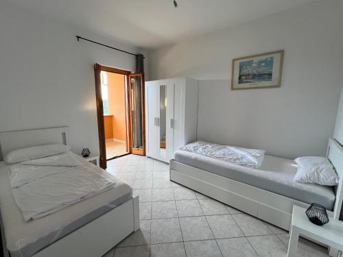 a bedroom with two beds and a door to a balcony at Villa di Mergo - Privatunterkunft, Ponzano Romano in Ponzano Romano
