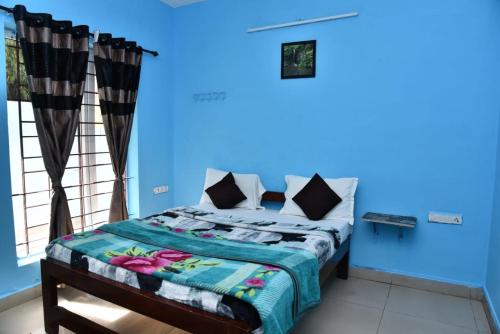 Cama en habitación con pared azul en Mel Rose Cottage Ooty, en Ooty