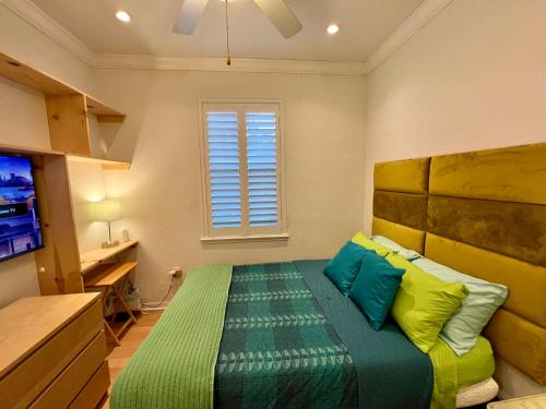 a bedroom with a bed with green and yellow pillows at The Scandinavian Contemporary Blauw in Lake Alfred