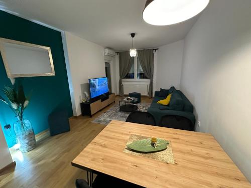 a living room with a table and a couch at Apartman Besta in Banja Luka