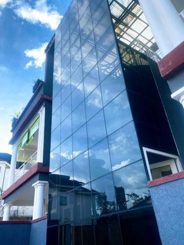 a building with a reflection of the sky in its windows at ADRIEL HOMES KIGALi in Kigali