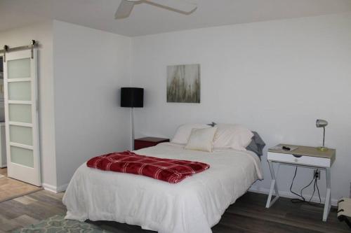a bedroom with a bed with a red blanket on it at Downtown Condo in Little Rock