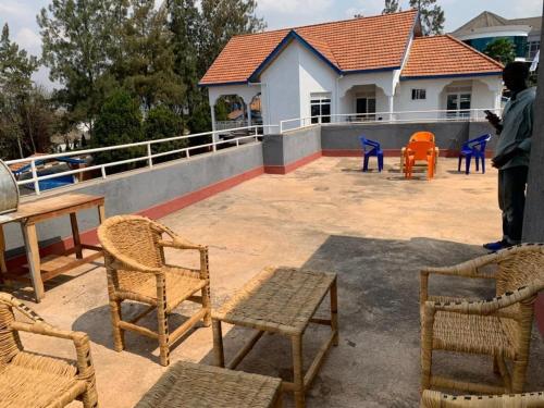 eine Gruppe von Stühlen und Tischen auf einer Terrasse in der Unterkunft ADRIEL HOMES KIGALi in Kigali