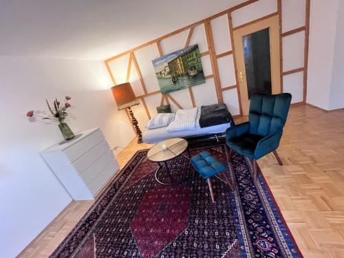 ein Wohnzimmer mit einem Sofa, einem Tisch und einem Stuhl in der Unterkunft Apartment Hölderlin in Seevetal