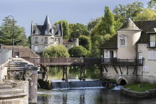 un puente sobre un río con un castillo en el fondo en Spacieux duplex en plein centre-ville de Fontainebleau, en Fontainebleau