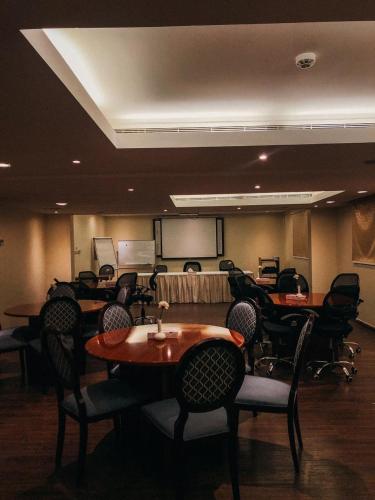 a conference room with tables and chairs and a projection screen at فندق فيلي للشقق الفندقية Filly Hotel Apartments in Hail