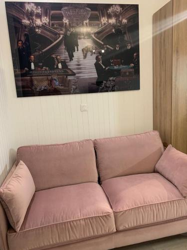 un sofá en una sala de estar con una foto en la pared en chez Caroline, en Annecy