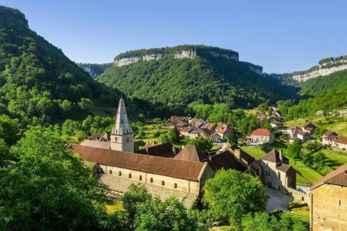 - une vue aérienne sur une ville avec une église et des montagnes dans l'établissement L'Alambic à Martial, à Ménétru-le-Vignoble