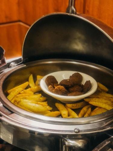 a plate of food in a pot with french fries at فندق فيلي للشقق الفندقية Filly Hotel Apartments in Hail