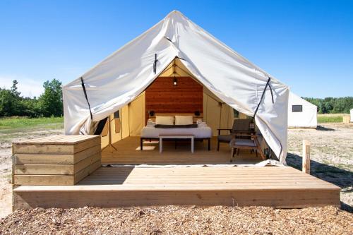 a tent with a bed on a wooden deck at Off Map Glamping in South Haven