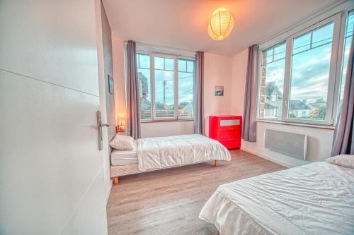a bedroom with two beds and a window at Villa Orkagna in Perros-Guirec
